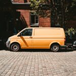 yellow van parked beside brown brick building